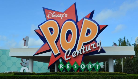 Foto da placa na entrada do hotel Pop Century, com fundo vermelho e letras em laranja e branco.