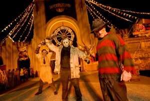 Imagem da festa de halloween da Universal, a Halloween Horror Nights, mostrando pessoas caracterizadas, entre elas Leatherface, Jason e Freddy Krueger.