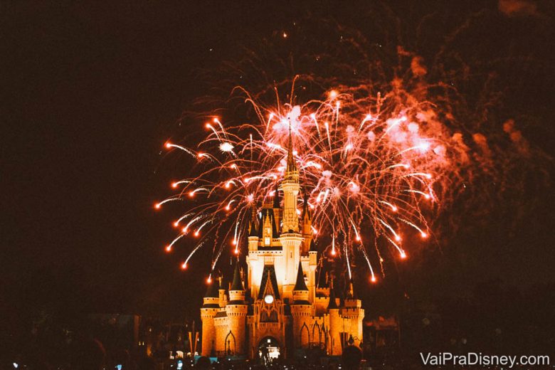 Foto do show de fogos Happily Ever After acontecendo, com o castelo da Cinderela ao centro e os fogos em tons de vermelho no céu. 