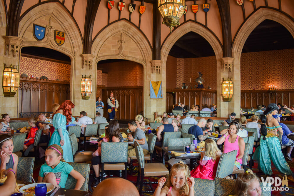 Foto do restaurante Cinderella's Royal Table, com diversos visitantes pelas mesas e as princesas passando entre eles para tirar fotos.