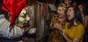 Foto de visitantes levando um susto com um personagem mascarado na Halloween Horror Nights da Universal