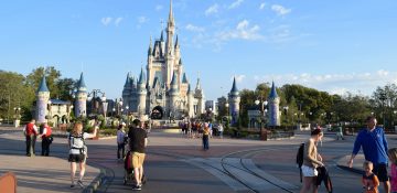 Foto do Magic Kingdom quase vazio, com o castelo da Cinderela ao fundo e alguns visitantes circulando