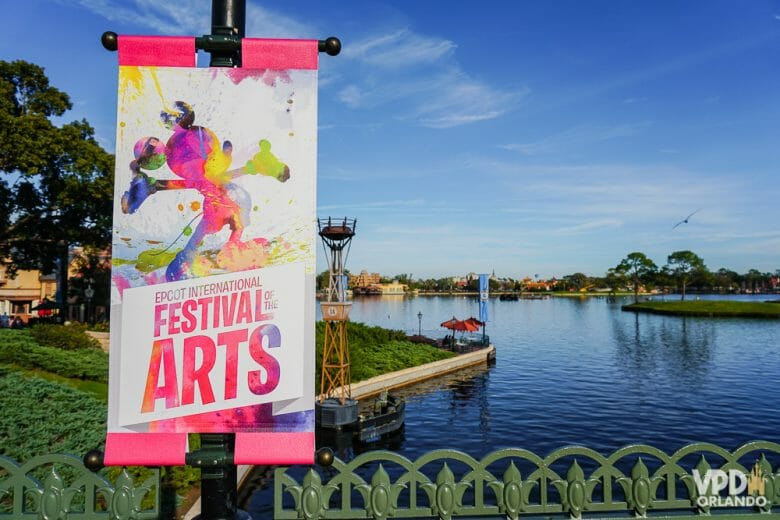 O Festival of the Arts acontece no Epcot! Foto do lago do Epcot com um pôster do Festival of the Arts, com um Mickey multicolorido em aquarela. 