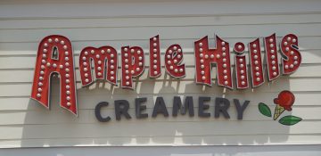 Foto da fachada da Ample Hills Creamery, no BoardWalk da Disney. O fundo é branco e as letras são em vermelho e preto.