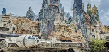 Foto da área de Star Wars no Hollywood Studios, a Galaxy's Edge. É possível ver a Millenium Falcon e as montanhas de Batuu ao fundo.