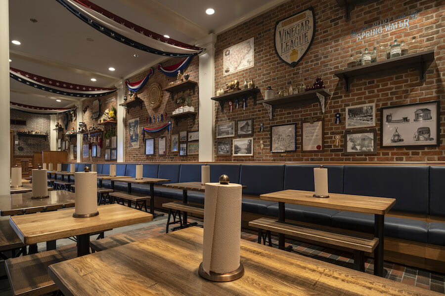 Foto do interior do novo restaurante do Epcot, o Royal Eagle Smokehouse, com decorações rústicas em madeira