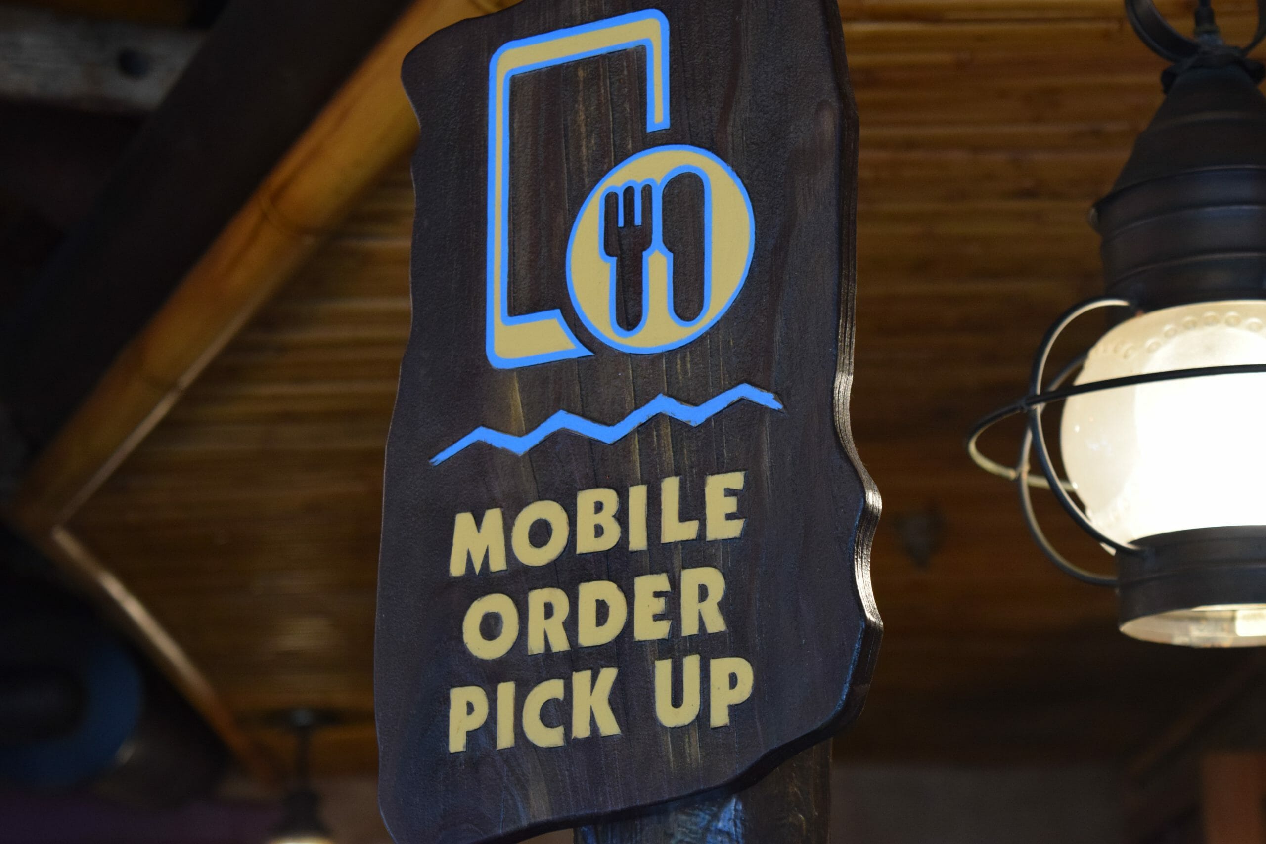 Foto de uma placa na Disney que diz "Mobile Order pick-up", indicando o local onde se retira o pedido feito pelo Mobile Order no aplicativo