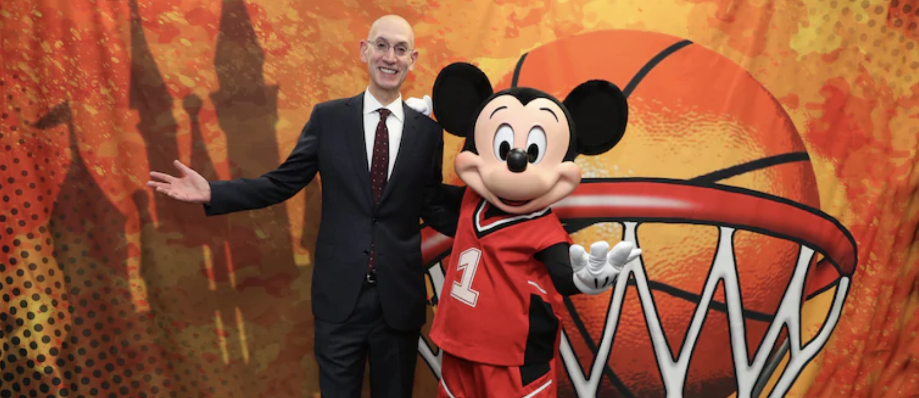 Foto divulgada pela NBA com o coordenador da liga ao lado do Mickey, vestido com roupa de basquete, o castelo da Cinderela e uma bola de basquete ao fundo.