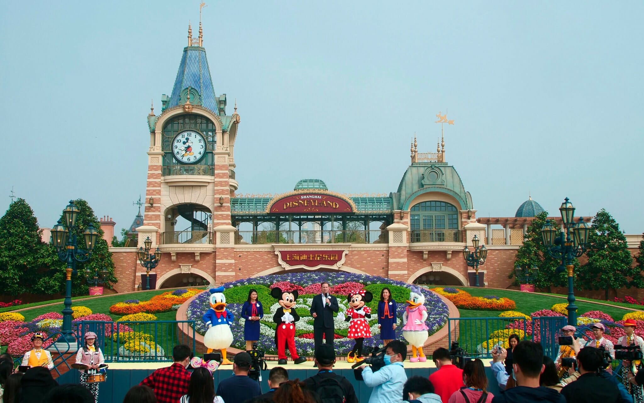 Foto da reabertura da Disneyland de Shanghai, que contou com personagens em frente ao parque enquanto o vice-presidente fazia um discurso