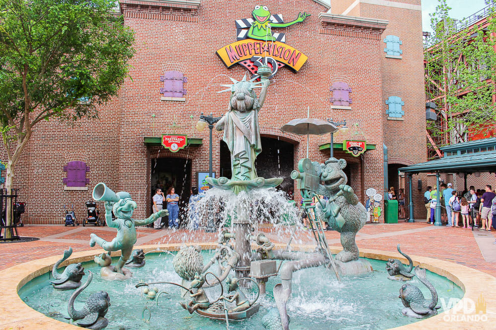 Foto da fonte que fica em frente à atração dos Muppets no Hollywood Studios, que tem os personagens esculpidos em pedra em diferentes poses, com a Miss Piggy de Estátua da Liberdade ao centro.