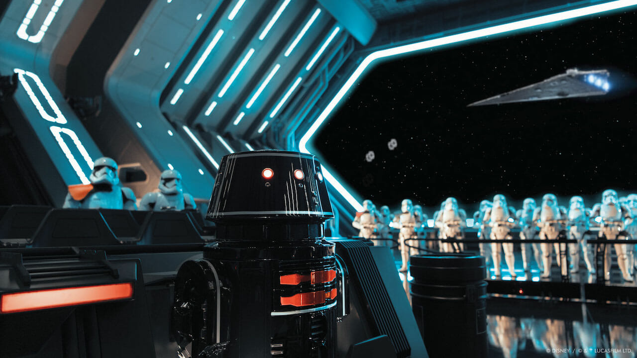 Foto de um dos momentos da Rise of the Resistance com os stormtroopers, e um droid R2 preto em primeiro plano.