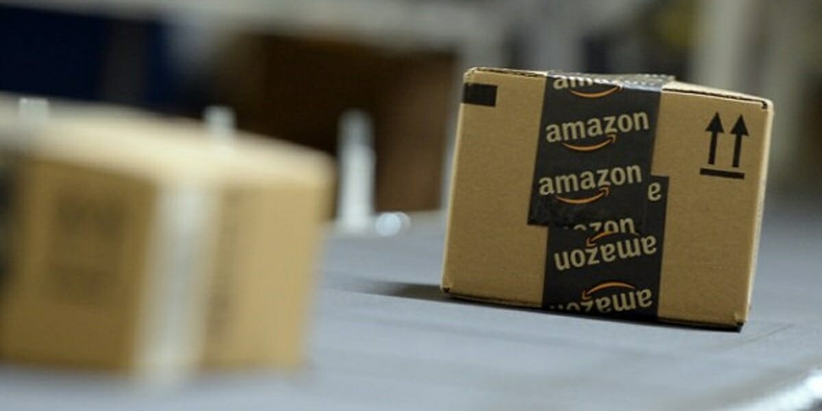 Caixas de entrega da amazon, em papelão com fitas pretas com o símbolo da loja