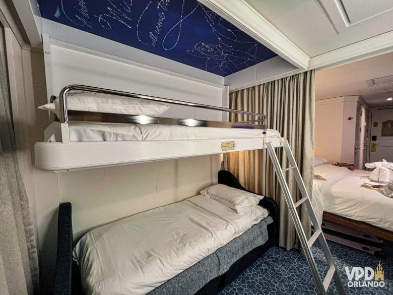 beliches e cama de casal em uma cabine no navio Disney Wish